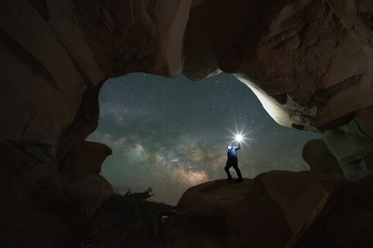 Man standing in a natural rock window in Devils Garden Escalante, Utah