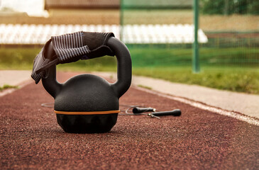 Naklejka na ściany i meble Kettlebell, jumping ropes and wrist wraps on empty stadium ready for outdoor workout