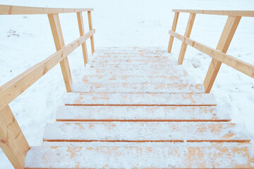 wooden steps and snow-covered railings leading down