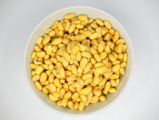 Soybeans after soaking for 24 hours in a bowl on a white background