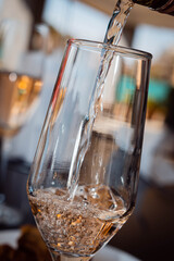 primer plano de bebida gaseosa vino espumante de color ambar claro transparente en copa alargada 