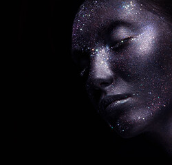 Portrait of beautiful woman with art space makeup on her face and body. Glitter Face.