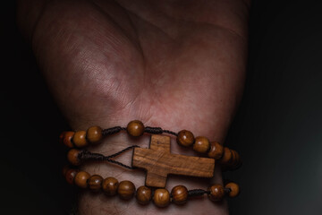 wooden rosary wrapped on the palm
