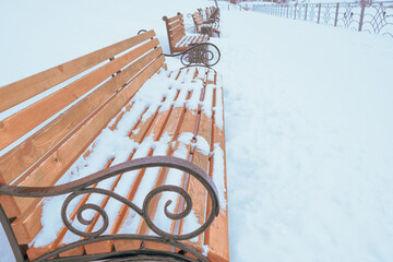 empty wooden benches in a row in winter