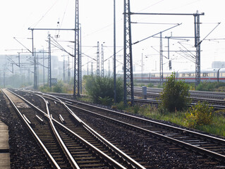 Railroad, tracks and train. City landscape with railway in the fog. Morning light in Berlin