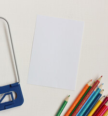 mockup, scene creator with an empty sheet of paper, colored pencils and a book stand.