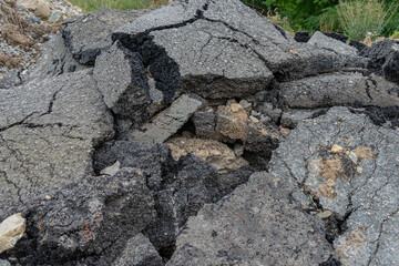 Old rough broken asphalt road pieces debris heap salvage construction material 