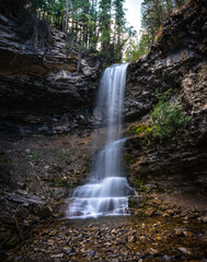 Naklejka na ściany i meble Magical waterfall flowing over rock canyon.