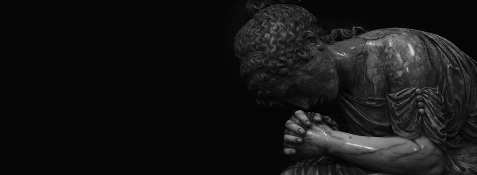 Fragment of an ancient statue of sad and desperate woman on tomb as a symbol of death, pain, sadness and sorrow. Horizontal image with free copy space for design or text.