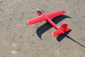 red styrofoam plane is on asphalt top view