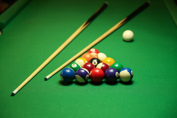 pool balls and cues are on billiard table