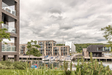 Harbour marina with modern apartments and sailingboats in the canal