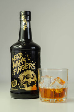 LONDON, UNITED KINGDOM - AUGUST 04, 2020 A glass with spiced rum called Dead Man's Fingers and ice cubes and a distinctive black bottle