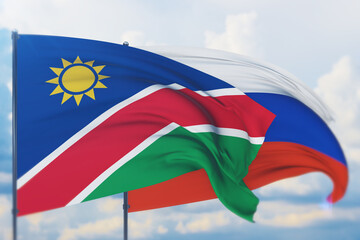 Waving Russian flag and flag of Namibia. Closeup view, 3D illustration.