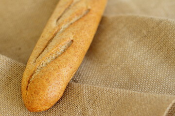French baguette on sackcloth material, fresh bread on burlap