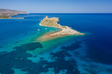 Tiny barren island surrounded by a crystal clear tropical Aegean sea (Crete, Greece)
