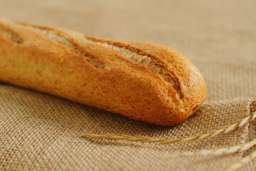 French baguette on sackcloth material, fresh bread on burlap