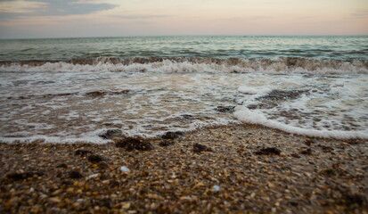 Beautiful waves on the sea beach in the evening. Sea sunset. Sunset over the sea beach