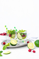 Mojito cocktail with lime, raspberry and mint in a glass. Fresh summer cocktail. Summer mojito
