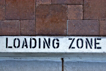Loading zone stensiled on white curb