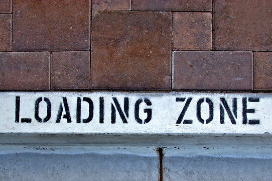 Loading zone stensiled on white curb