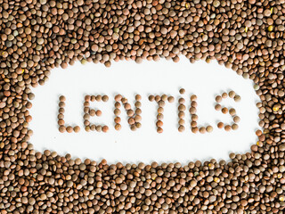 Overhead shot of lentils with their name formed by lentils on white background.