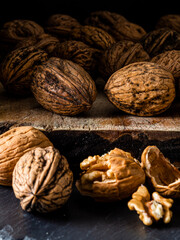 Macro photography of walnuts on cutting board and dark background. 