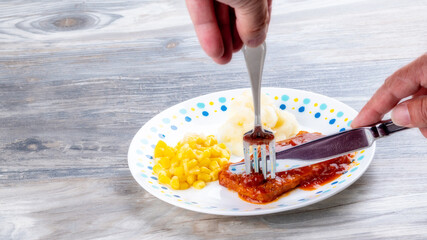 Meat selection is sliced with a knife and fork