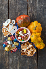 Halloween Jack o Lantern candy bowl with candy and halloween cookies Trick or Treat on wooden background