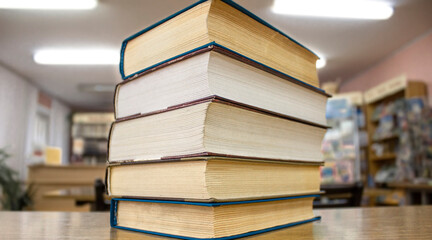 Old books on a wooden shelf with blurred backgrund