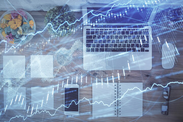 Stock market graph and top view computer on the table background. Multi exposure. Concept of financial education.