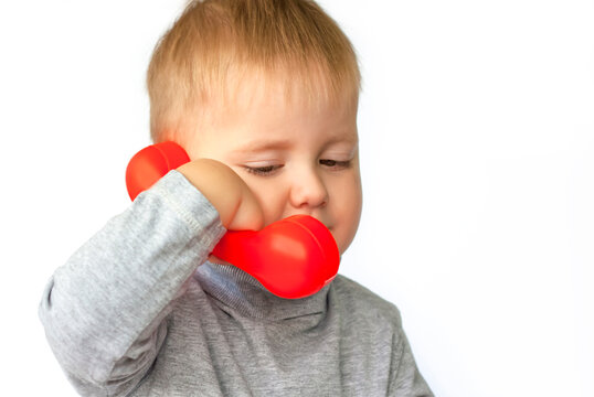 Portrait of an astonished cute little boy holding a red telephone receiver. Call here, call soon! The child is isolated on a white background.  Concept for an advertising banner. - Powered by Adobe
