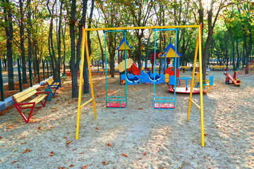Fototapeta na wymiar children's playground in a city Park early in the morning, various swings and carousels