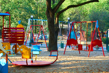 children's playground in a city Park early in the morning, various swings and carousels