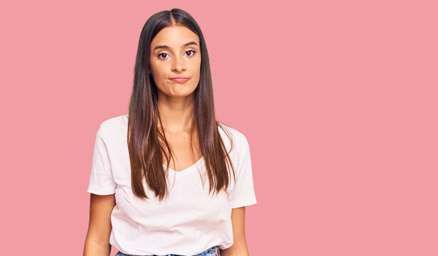 Young hispanic woman wearing casual white tshirt looking sleepy and tired, exhausted for fatigue and hangover, lazy eyes in the morning.