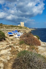 Sunbeds on the cliff of Mgarr Ix-Xini in Gozo, Malta