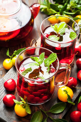 Glass cups and tea pot with berry  tea  on  wooden  background