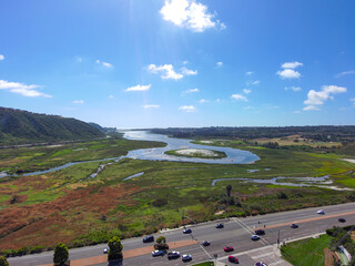 a stunning aerial shot of the deep blue waters and the lush green trees at Batiquitos Lagoon in...