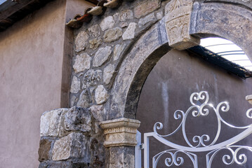 Architrave in pietre antiche con cancello bianco