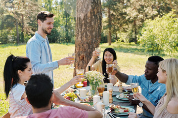 Restful international friends going to clink with glasses of wine during toast