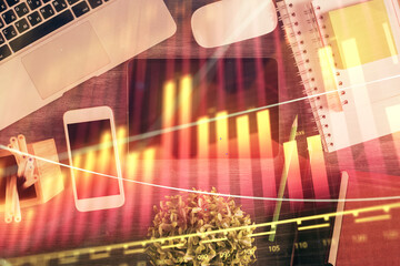 Double exposure of forex chart hologram over desktop with phone. Top view. Mobile trade platform...