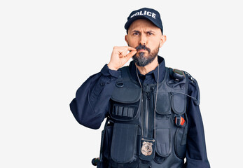 Young handsome man wearing police uniform mouth and lips shut as zip with fingers. secret and...