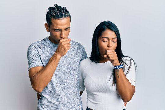 Young latin couple wearing casual clothes feeling unwell and coughing as symptom for cold or bronchitis. health care concept.