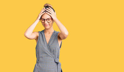 Beautiful caucasian woman with blonde hair wearing business clothes and glasses suffering from headache desperate and stressed because pain and migraine. hands on head.