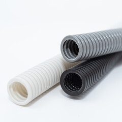PVC flexible electrical conduit isolated on white background. Plastic curvilinear hoses. Colored...
