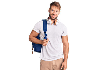 Young caucasian man wearing student backpack and headphones looking positive and happy standing and smiling with a confident smile showing teeth