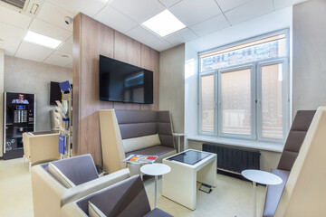 The waiting area in a modern sales office with a vending coffee machine, soft leather sofas and a coffee table