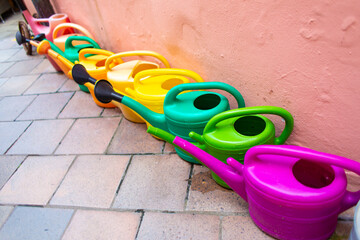 Set of multi-colored plastic watering cans for garden care