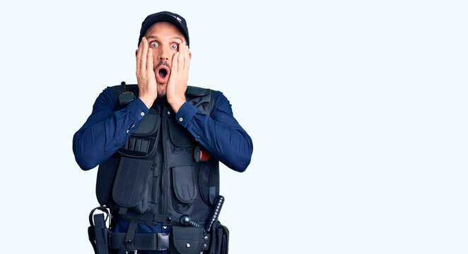 Young handsome man wearing police uniform afraid and shocked, surprise and amazed expression with hands on face