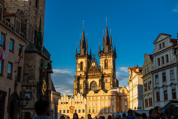 Fototapeta na wymiar Tyn Temple on the Old Town Square in Prague. A crowd of tourists walk on the Old Town Square in Prague